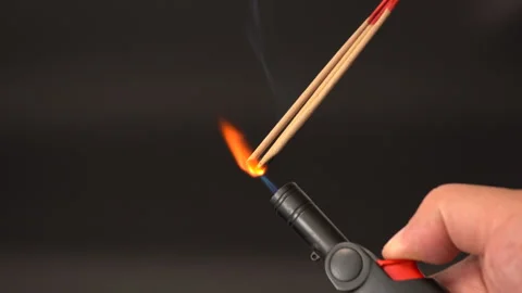 Lighting incense stick with handheld black lighter, close up of hand igniti.. Stock Footage 315513997