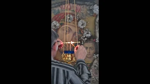 Lighting a lamp in front of the icon of the Kazan Mother of God. Stock Footage 131868605