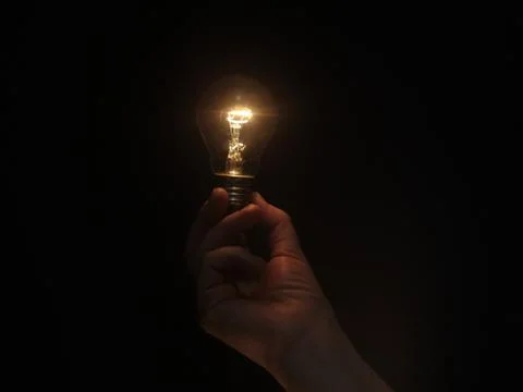 Lighting lamp in hand Stock Photos