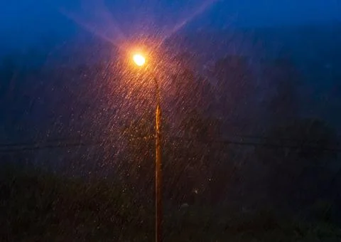 Lighting lantern in heavy rain. 库存照片