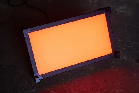 Lighting LED panel stands on the floor and shines with orange light Stock Photos