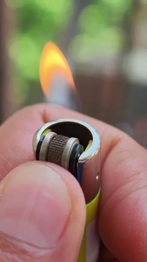 Lighting a lighter, creating a flame with a flint wheel Vidéo 310880331