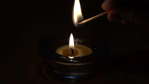 Lighting a match with a candle flame Video stock 230325363