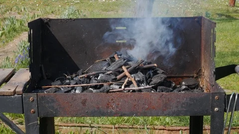 Lighting up an old, rusty grill, smoke and fire Stock Footage 88575010