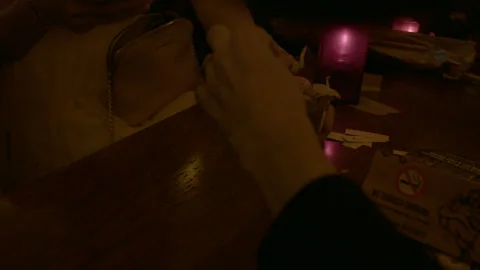 Lighting a Paper Joint Tip at Table in Coffeeshop Stock Footage 344603763
