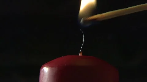 Lighting a red candle with a match Stock Footage 4627528
