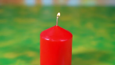 Lighting a red candle with a match on green background Stock Footage 143244980