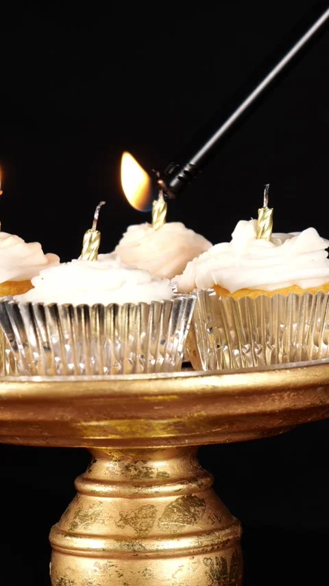 Lighting Some Silver Cupcakes on a Gold Tray with a Long Lighter in front of a Stock Footage 346644895