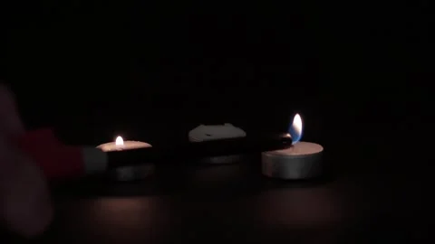Lighting three candles with a lighter on a dark background. Stock Footage 251856265