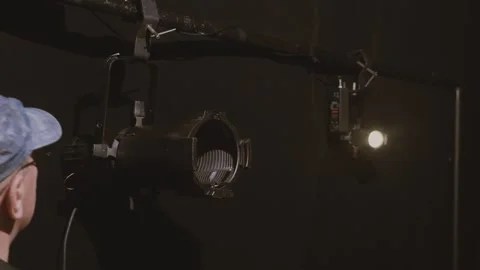 The lighting worker hangs a profile spotlight on the instrument stand. Clos.. Vidéo 310404226