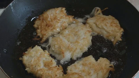 Lightly fried hash browns are fried in a pan in oil Stock Footage 108006814