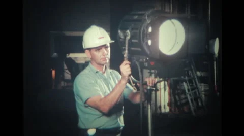 Lightman adjusting the light on the set Stock Footage 37437126