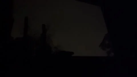 Lightning bolt illuminates silhouetted bedroom window with atmospheric flash Stock Footage 343877013