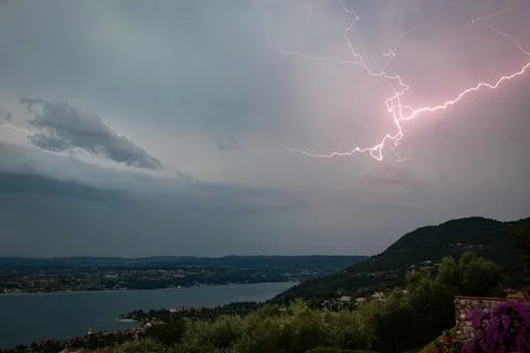 Lightning bolt illuminating the sky over the hills near Lake Garda, Italy. Stock Photos