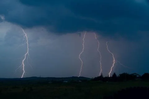 Lightning bolt striking in the sky from clouds Stock Photos