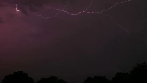 Lightning during a thunderstorm over trees in the night sky, time lapse Stock Footage 157073583