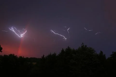 Lightning in the Evening with a Rainbow Stock Photos