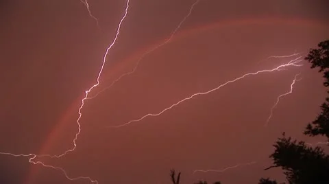 Lightning exploads through rainbow Stock Footage 12573763