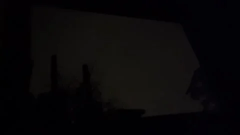 Lightning flash illuminates silhouetted bedroom window with atmospheric bolt Stock Footage 343876967