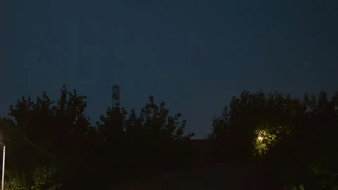 Lightning flashes illuminate the dark sky ahead of an approaching rainstorm Stock Footage 318821244