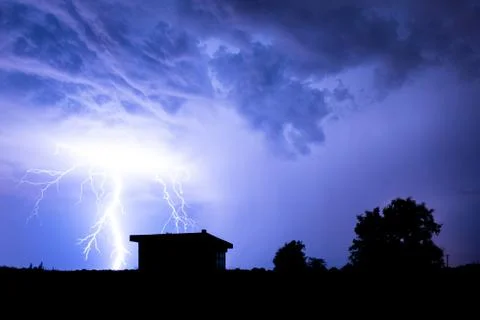 Lightning flashes over the night sky during thunderstorm. Stock Photos