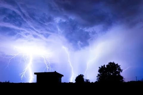 Lightning flashes over the night sky during thunderstorm. Stock Photos