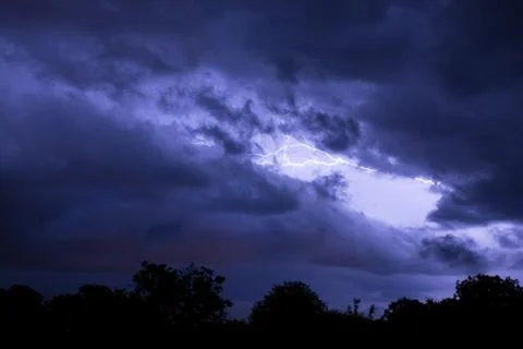 Lightning flashes over the night sky during thunderstorm. Stock Photos