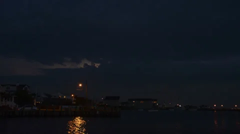 Lightning flashing in clouds over ocean bay in evening time lapse HD 1080 Stock Footage 27963944