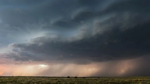 Lightning flashing through storm clouds moving over the landscape Stock Footage 120154034
