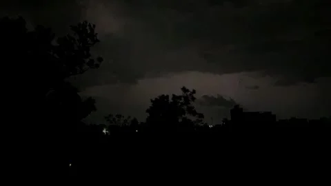Lightning forks through storm clouds under the night sky Stock Footage 337147827