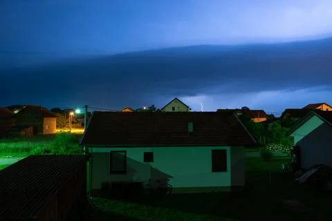 Lightning glow in clouds above suburbs at night Stock Photos