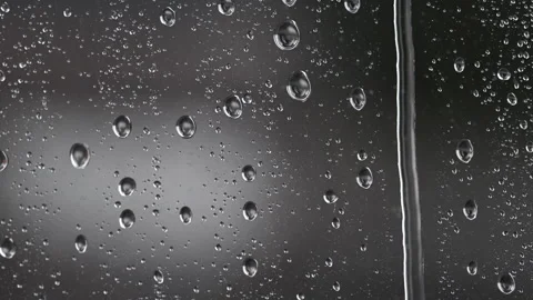 Lightning in a gray storm with rain and sleet behind wet shaking glass. 動画素材 326453293
