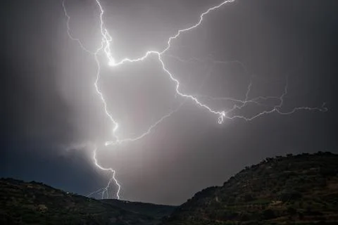 Lightning over hills Stock Photos