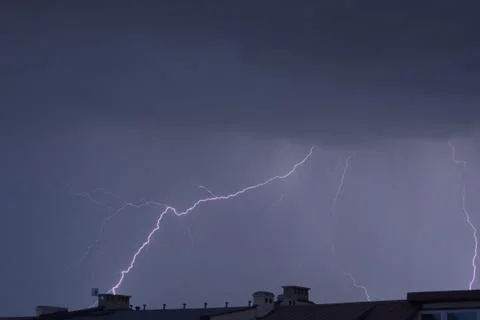 Lightning over rooftops Stock Photos