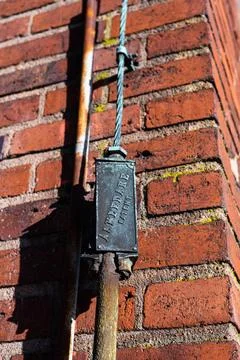 Lightning rod cable on the facade of a brick building. Lightning rod cable... Stock Photos