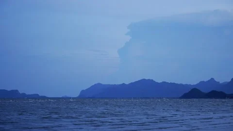 Lightning storm illuminates dramatic thunderclouds over mountains during Vídeos de archivo 314302451