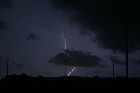 Lightning storm over wind farm at night under dark storm clouds Fotos Stock