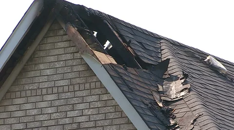 Lightning strike and fire burn damage to house roof Stock Footage 48841894