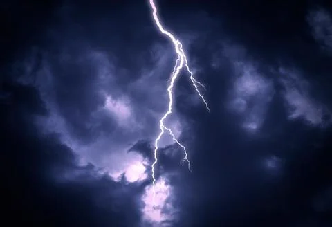 Lightning strike on a cloudy dark sky. Stock Photos