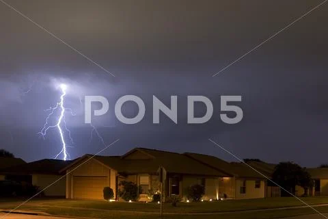 Lightning strike at night very near homes Stock Photos