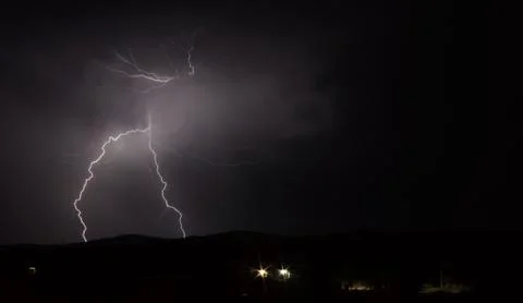 Lightning strike over mountain range with clouds Foto stock