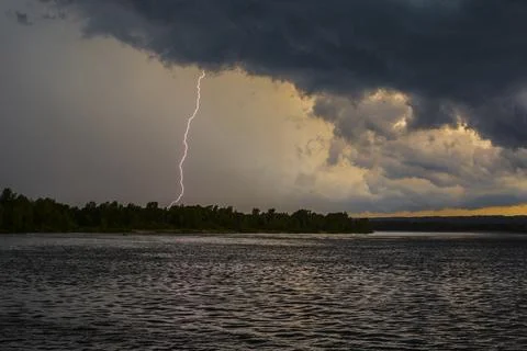 Lightning strike over the river, stormy weather, Stock Photos