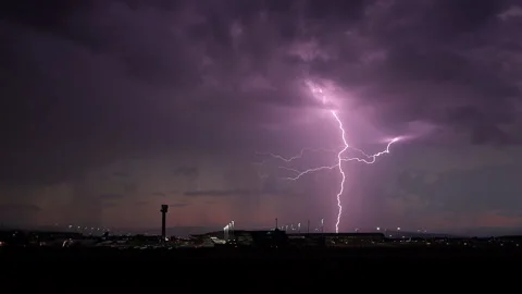 Lightning strikes airport late evening sunset horizon rain showers Stock Footage