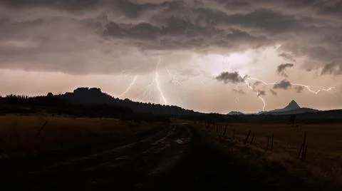 Lightning strikes in the distance on a rain wet road in Southern Utah Stock Photos