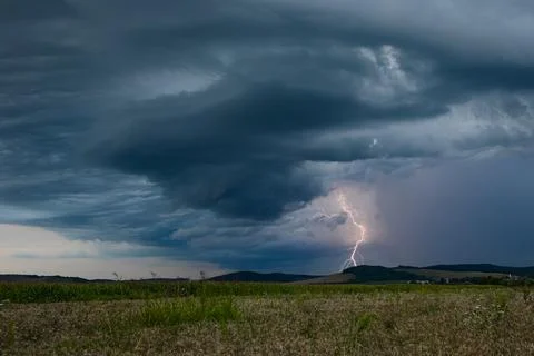 Lightning strikes down from a dramatic looking thunderstorm Stock Photos