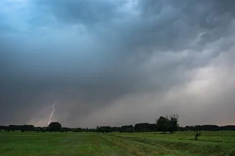 Lightning strikes down from a severe thunderstorm at dusk Stock Photos