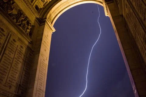 Lightning strikes through the arch at the Arc de Triomphe, Paris, France Stock Photos