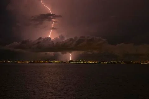 Lightning strikes through the cloud into the chimney of the factory, Singapore Stock Photos