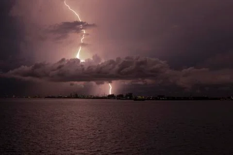 Lightning strikes through the cloud into the chimney of the factory, Singapore Stock Photos