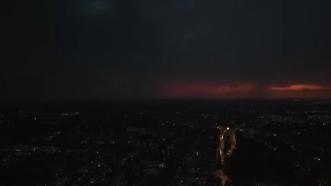 Lightning striking dark stormy sky over city street. Dramatic aerial view drone Stock Footage 339641206